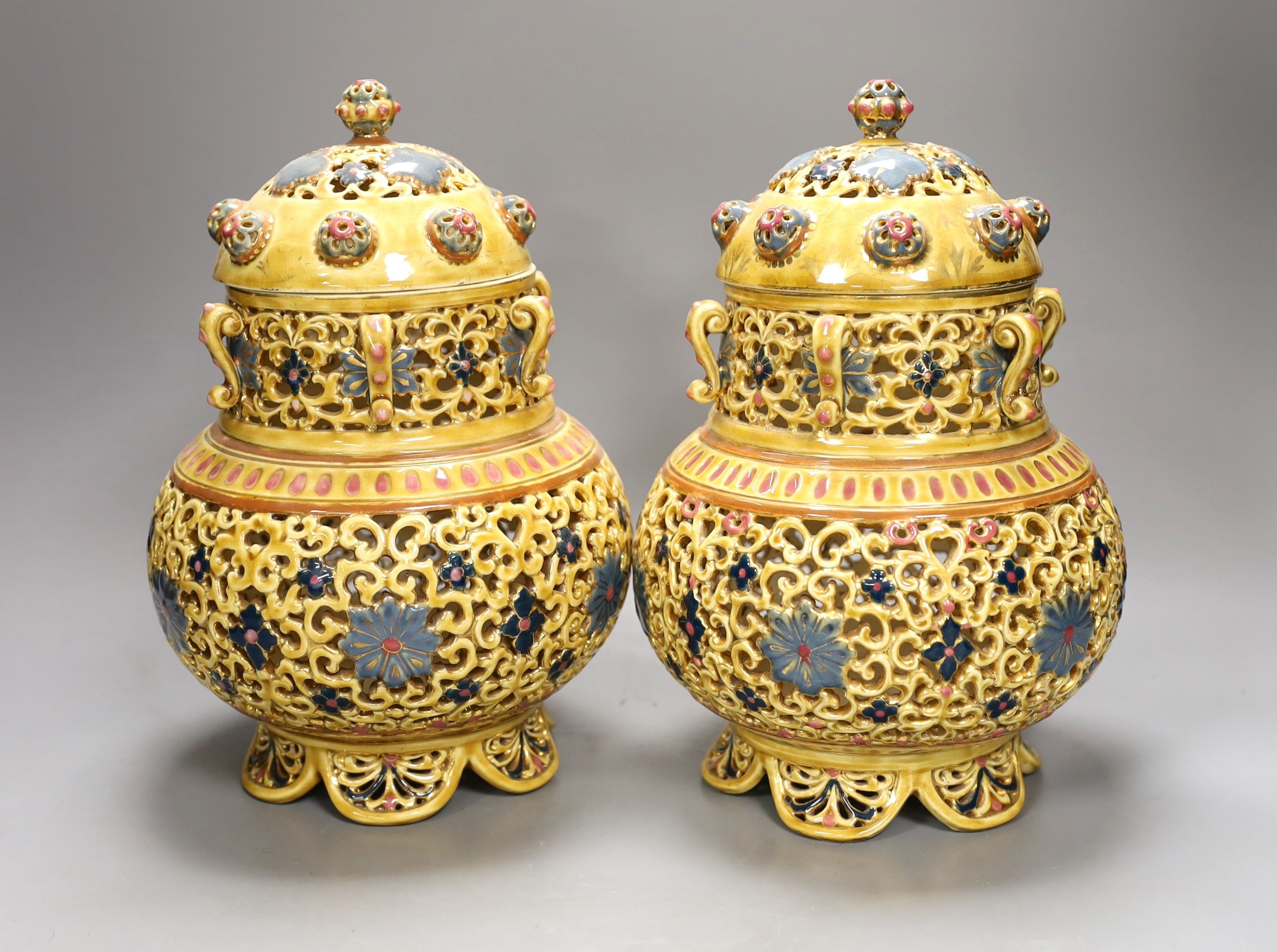 A pair of Zsolnay Pecs Persian inspired vases and covers, 27 cms high.